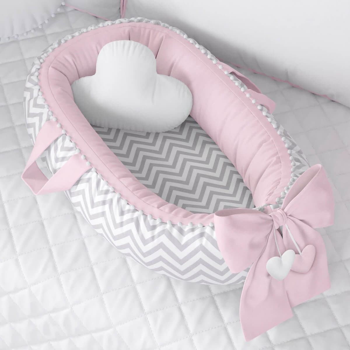 https://gdg-images.s3.sa-east-1.amazonaws.com/fotos/101644/ninho-para-bebe-redutor-de-berco-pompom-chevron-rosa-233076.jpg